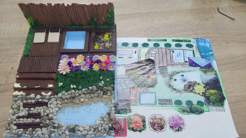 Ландшафтный макет с камнями и планом проекта рядом